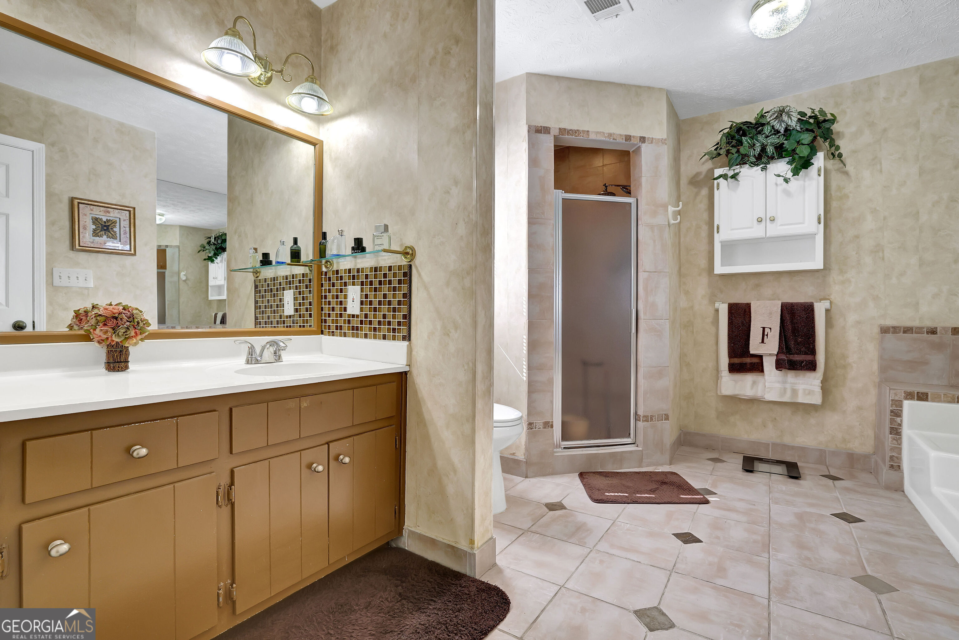 2613 Travois Way Southwest Lilburn, GA 30047 - Photo 21 of 40 a bathroom with a sink a mirror and a shower