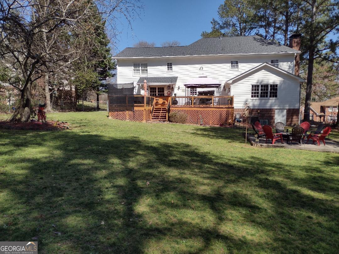 2613 Travois Way Southwest Lilburn, GA 30047 - Photo 4 of 40 a view of a yard with table and chairs under an umbrella
