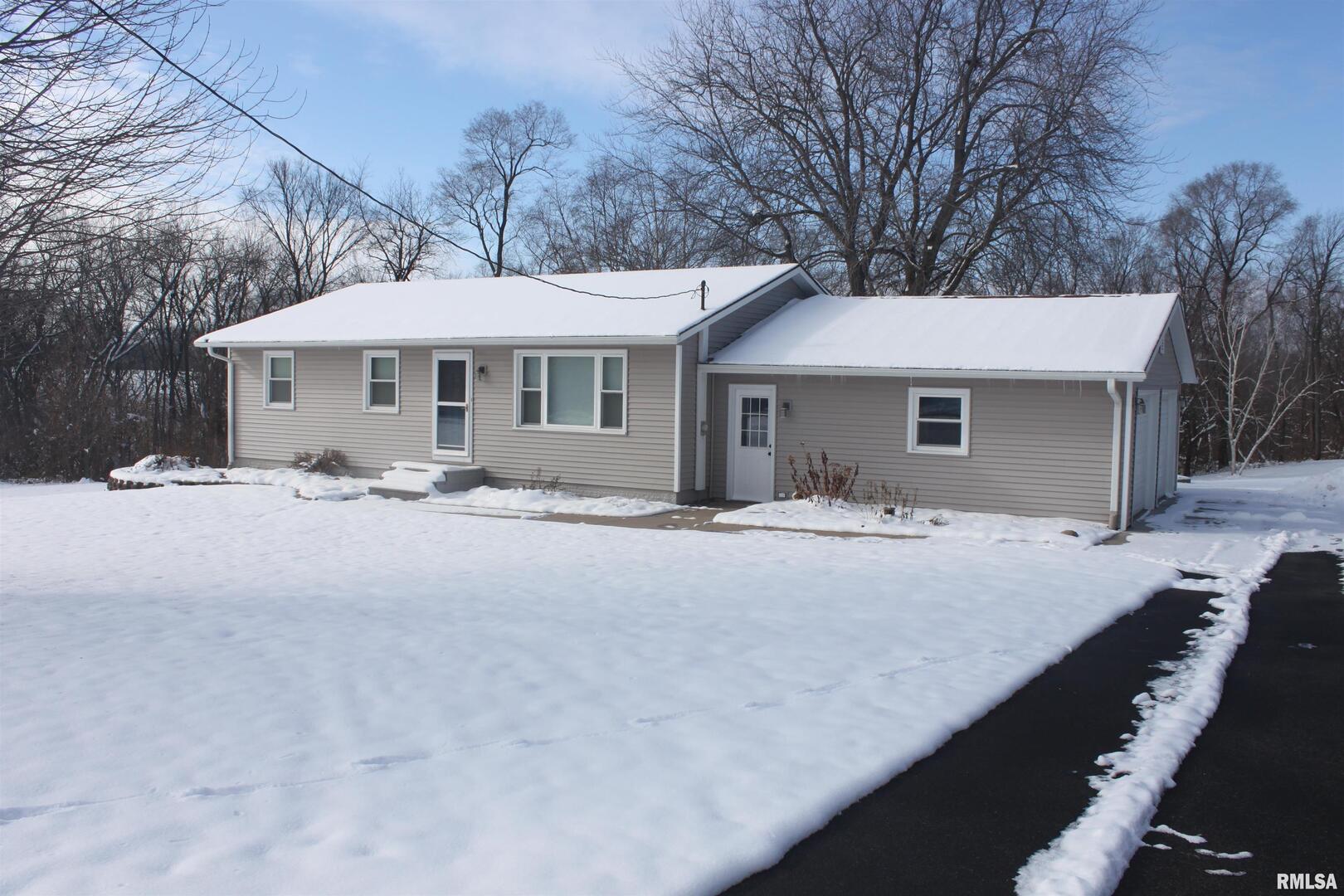 a front view of a house with yard covered with snow in front of house