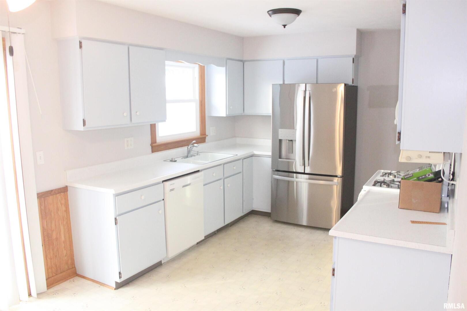 9012 98th Street West Taylor Ridge, IL 61284 - Photo 12 of 18 a kitchen with a refrigerator sink stove and cabinets