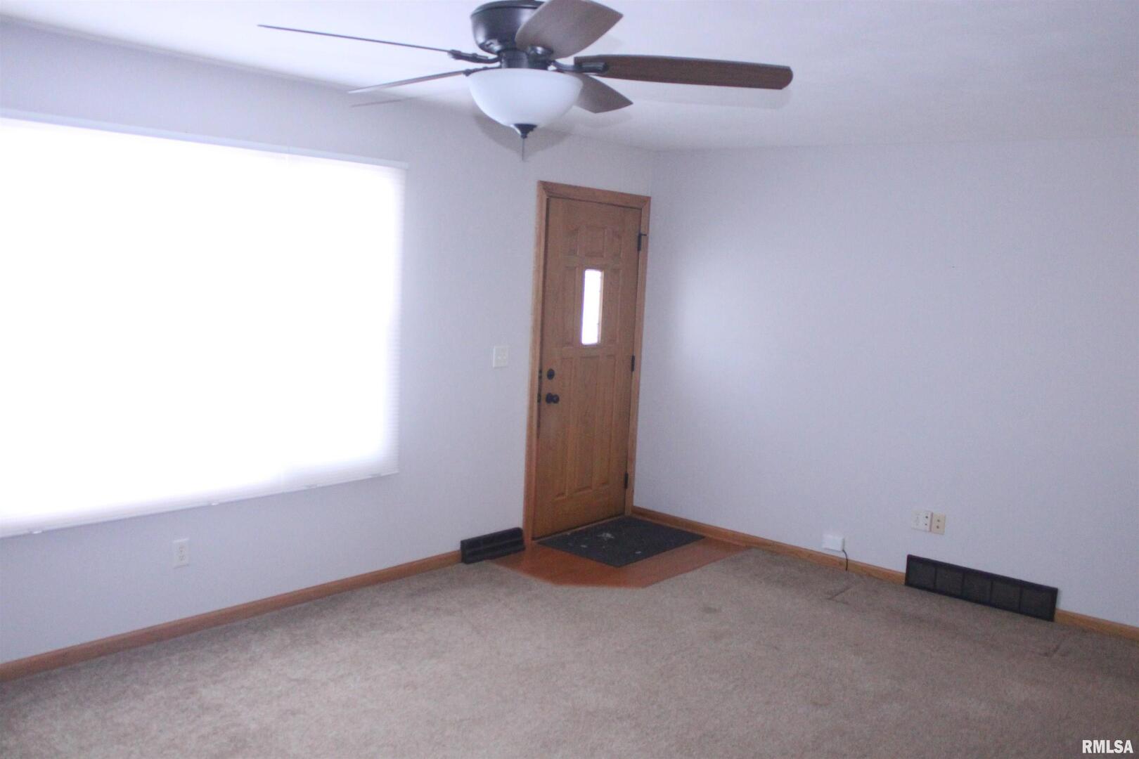 9012 98th Street West Taylor Ridge, IL 61284 - Photo 7 of 18 an empty room with a window and a fan