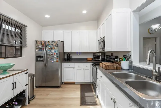 a kitchen with stainless steel appliances granite countertop a refrigerator sink and cabinets