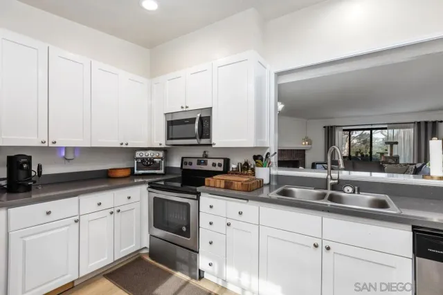 a kitchen with white cabinets and white appliances