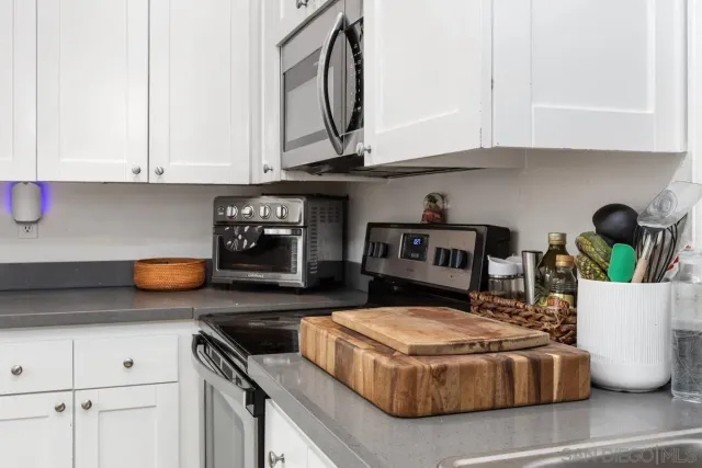 a kitchen with kitchen island granite countertop a sink a stove and cabinets