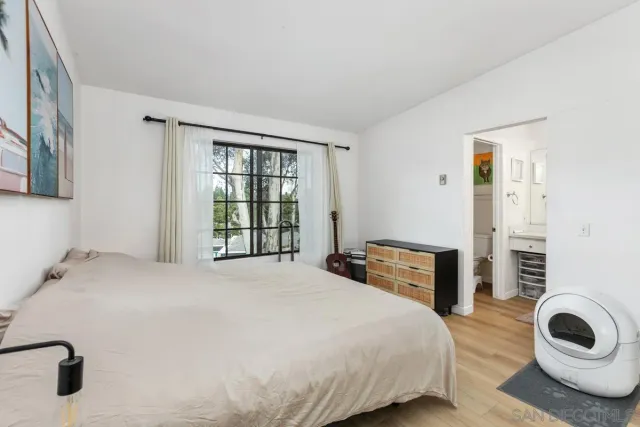 a bedroom with a bed and dresser with mirror