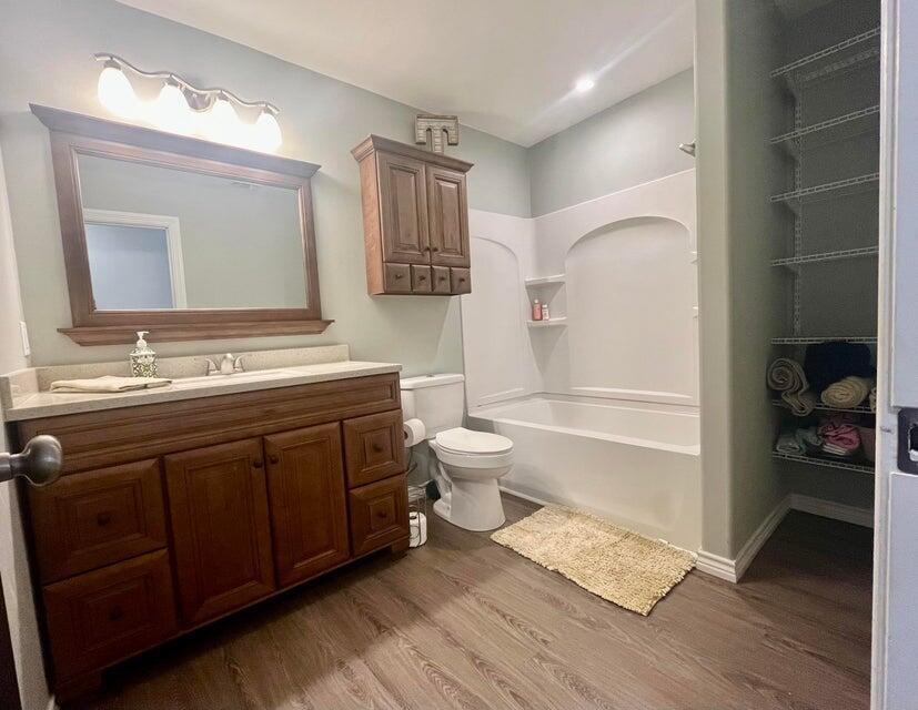 1209 Xenia Street Plainview, TX 79072 - Photo 14 of 31 a bathroom with a double vanity sink a toilet and a mirror
