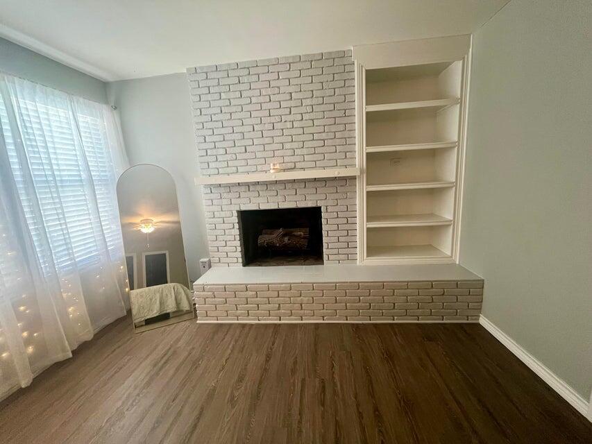 1209 Xenia Street Plainview, TX 79072 - Photo 23 of 31 a living room with a fireplace and wooden floor