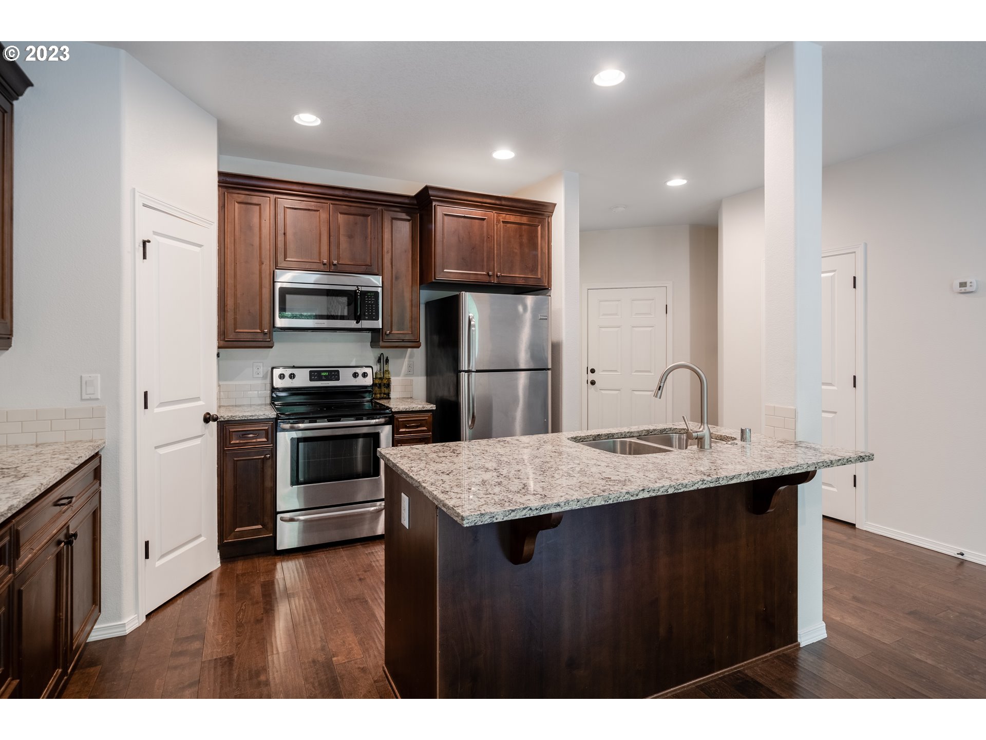 1405 Northeast 170th Circle Ridgefield, WA 98642 - Photo 8 of 32 a kitchen with a sink a refrigerator and a stove