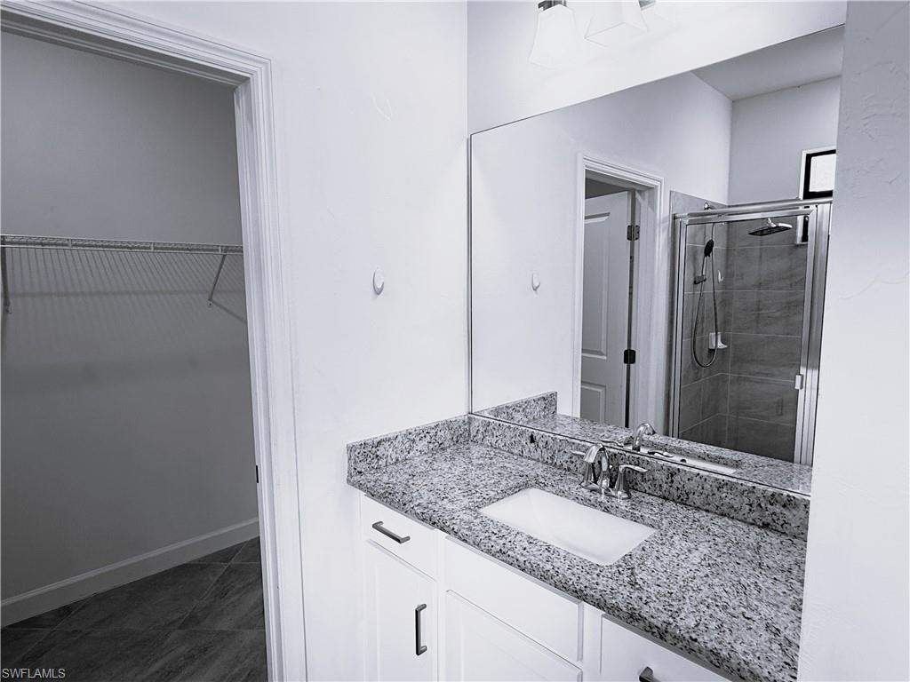 14063 Winding Cedar Way Fort Myers, FL 33913 - Photo 11 of 15 a bathroom with a granite countertop sink and a mirror