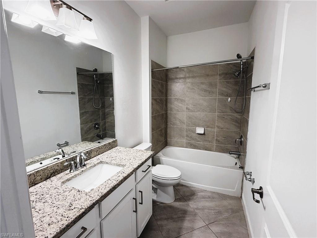 14063 Winding Cedar Way Fort Myers, FL 33913 - Photo 13 of 15 a bathroom with a granite countertop sink toilet mirror and bathtub