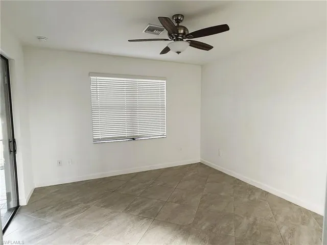 an empty room with fan and windows