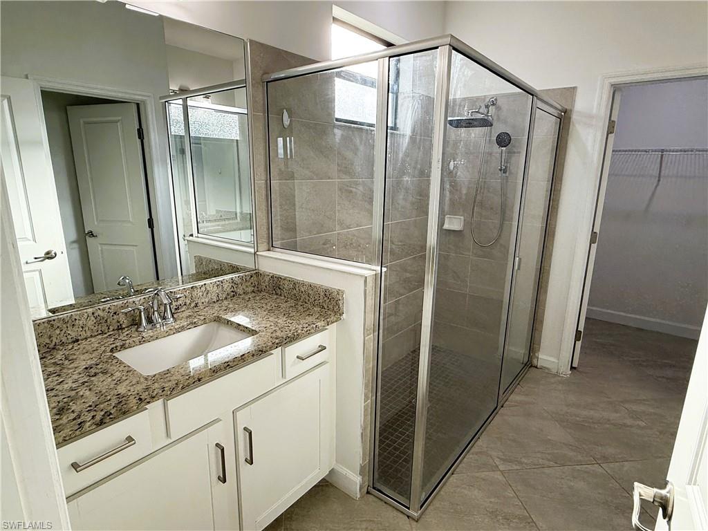 14063 Winding Cedar Way Fort Myers, FL 33913 - Photo 10 of 15 a bathroom with a granite countertop sink a mirror and shower