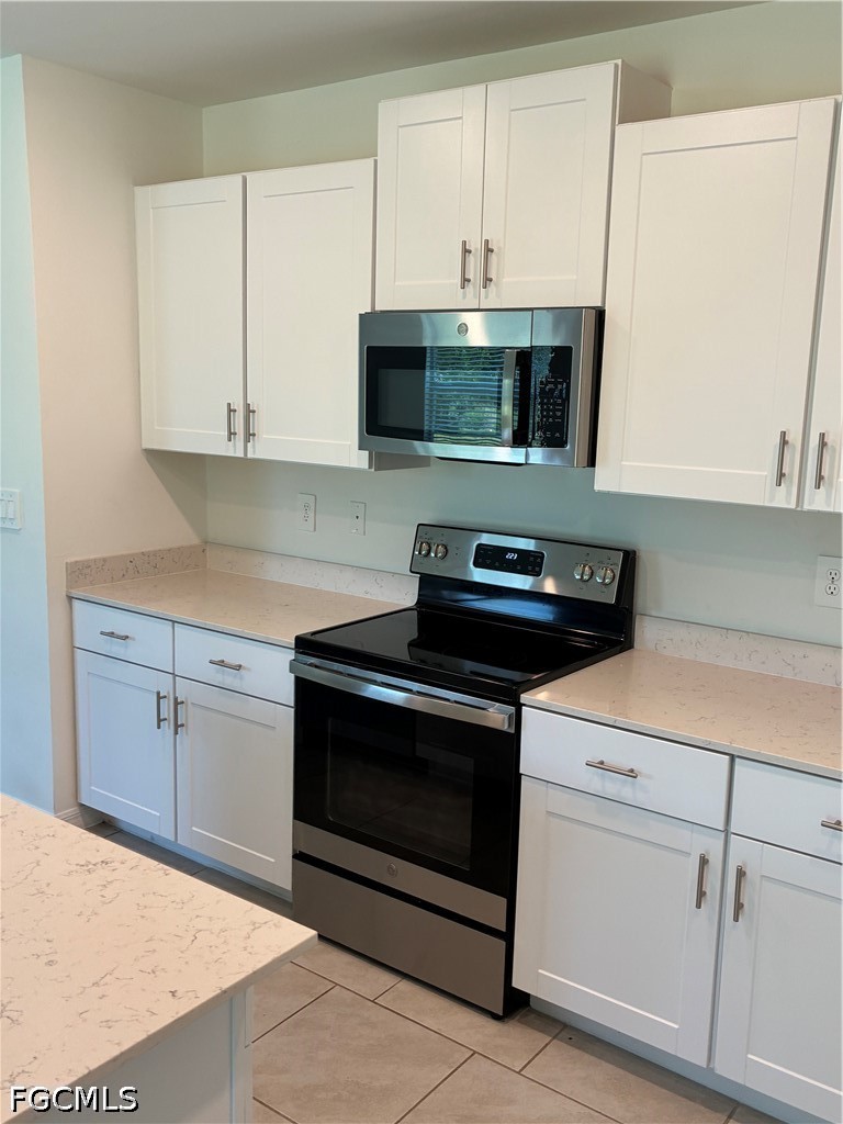 12441 Dakota Ridge Place Lehigh Acres, FL 33974 - Photo 7 of 16 a kitchen with a stove and a microwave