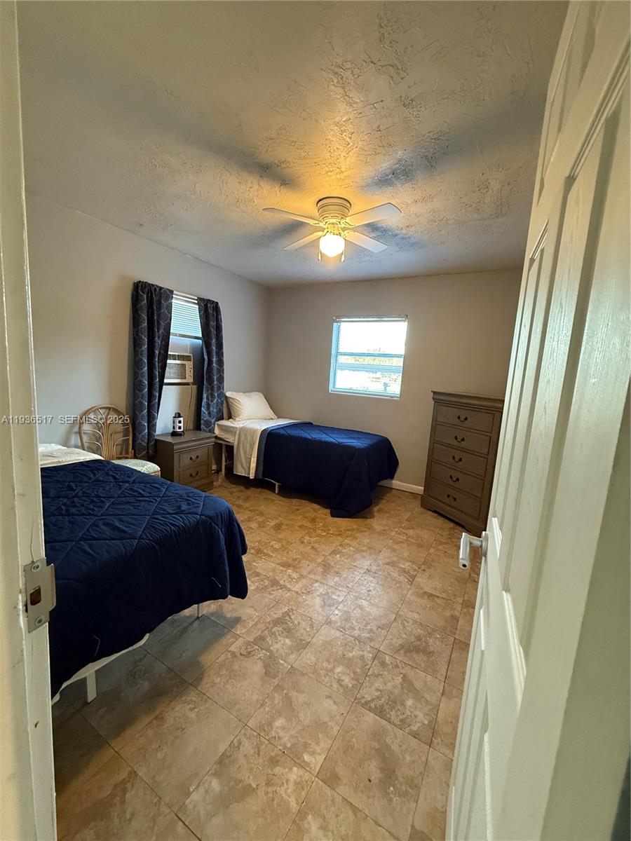 911 North 18th Street, Unit A Fort Pierce, FL 34950 - Photo 2 of 7 a bedroom with two beds and a chandelier