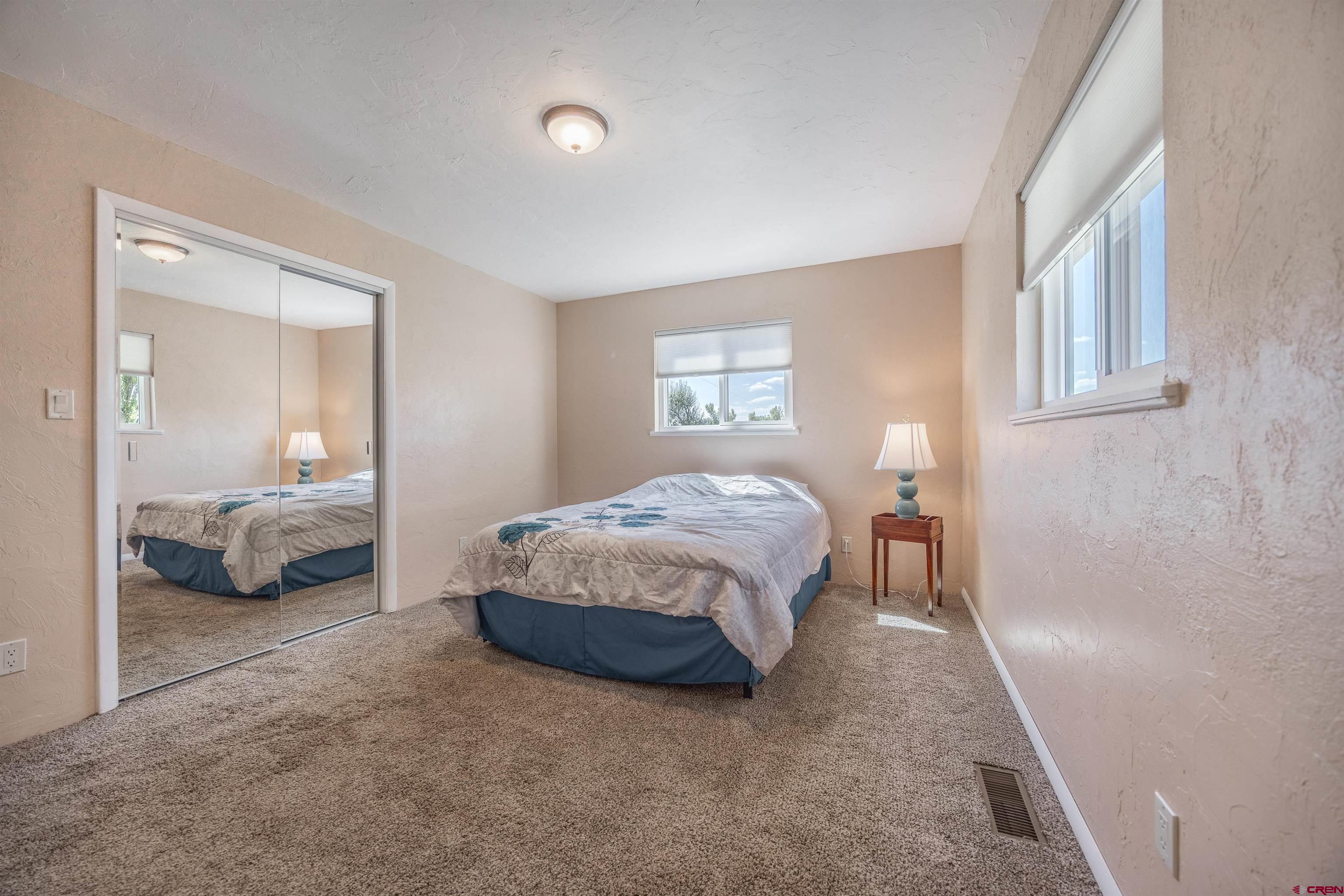 16574 6275th Road Montrose, CO 81403 - Photo 19 of 45 a spacious bedroom with a bed and a couch