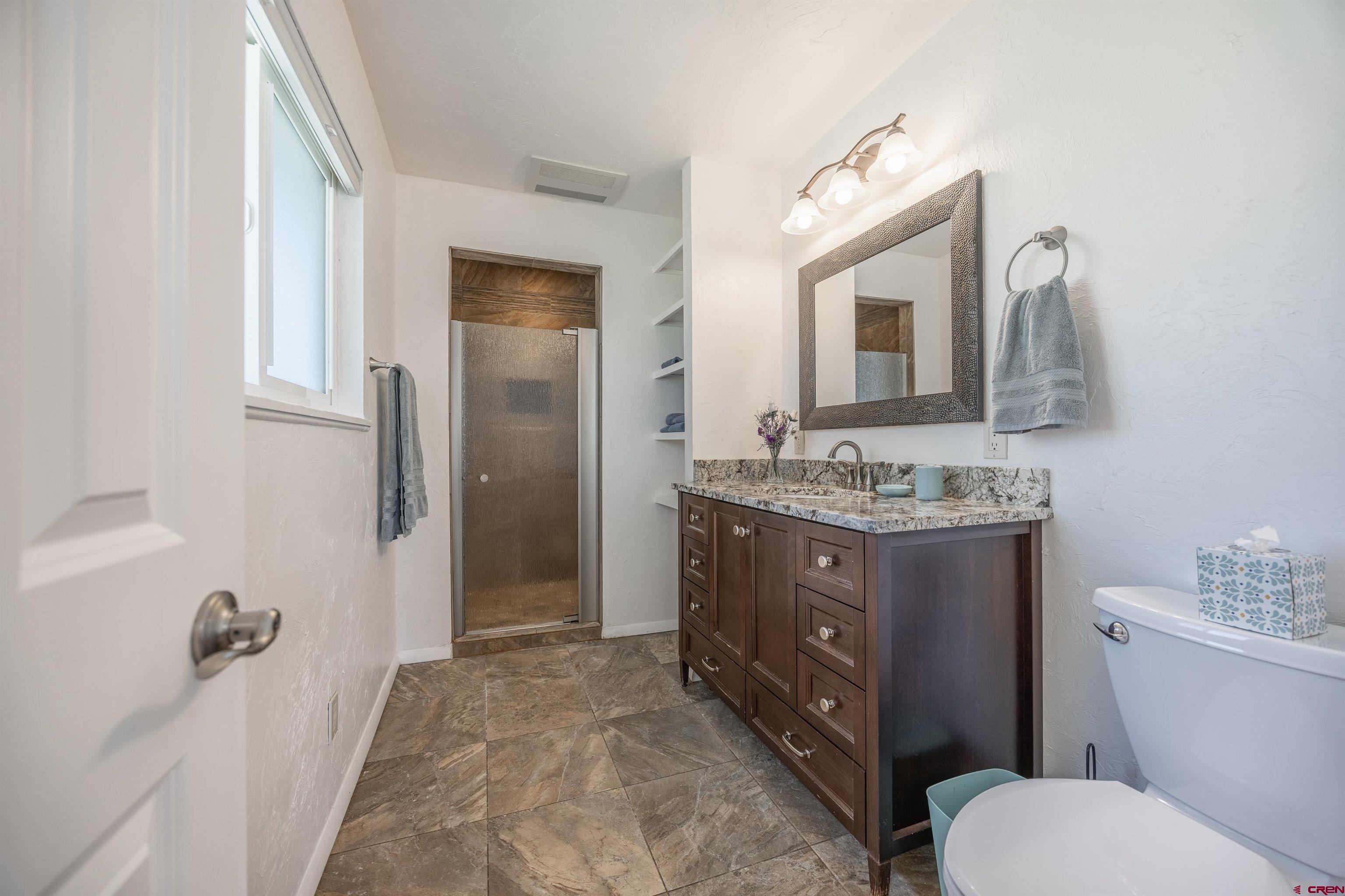 16574 6275th Road Montrose, CO 81403 - Photo 21 of 45 a bathroom with a granite countertop toilet sink and mirror