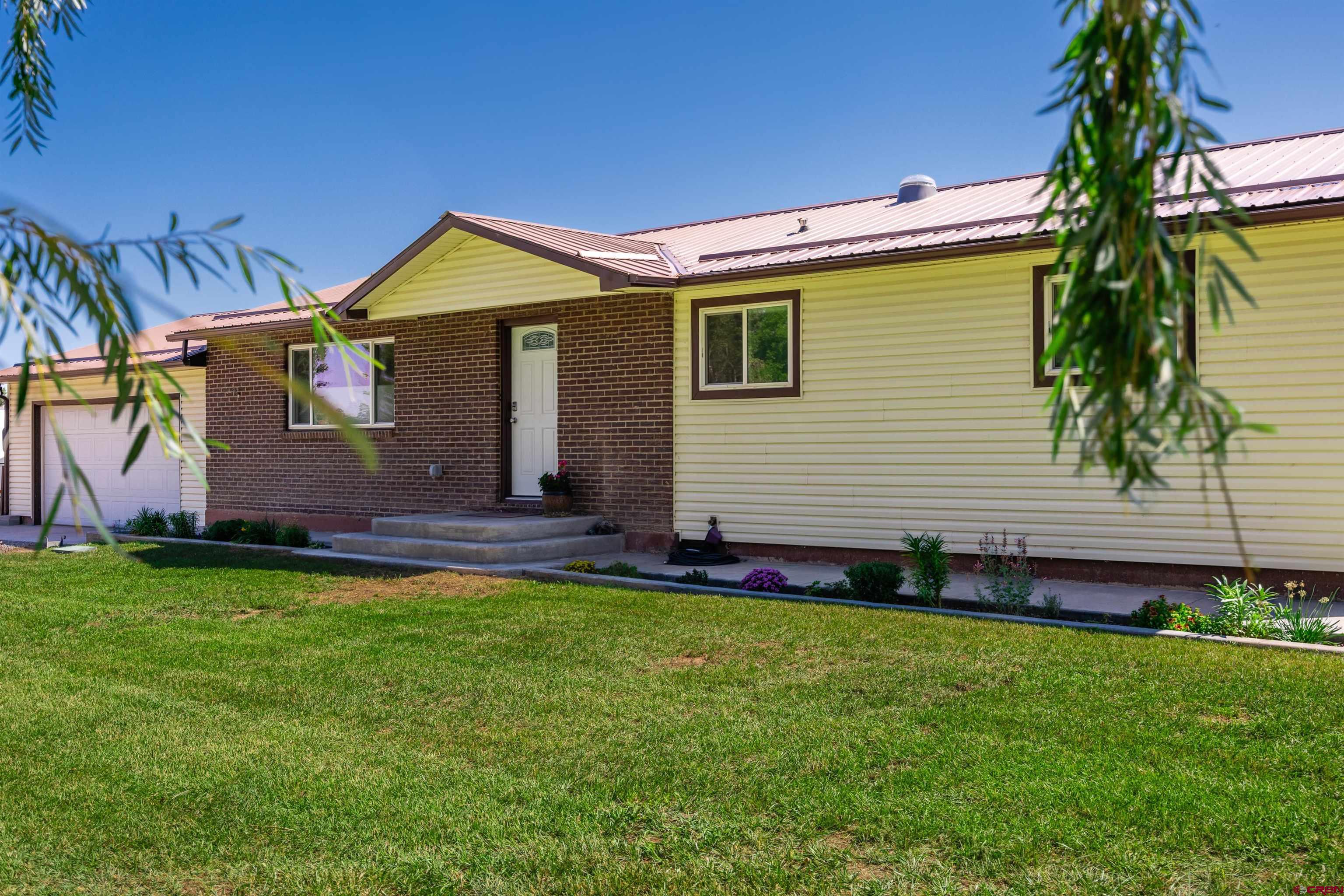 16574 6275th Road Montrose, CO 81403 - Photo 4 of 45 a front view of a house with a garden