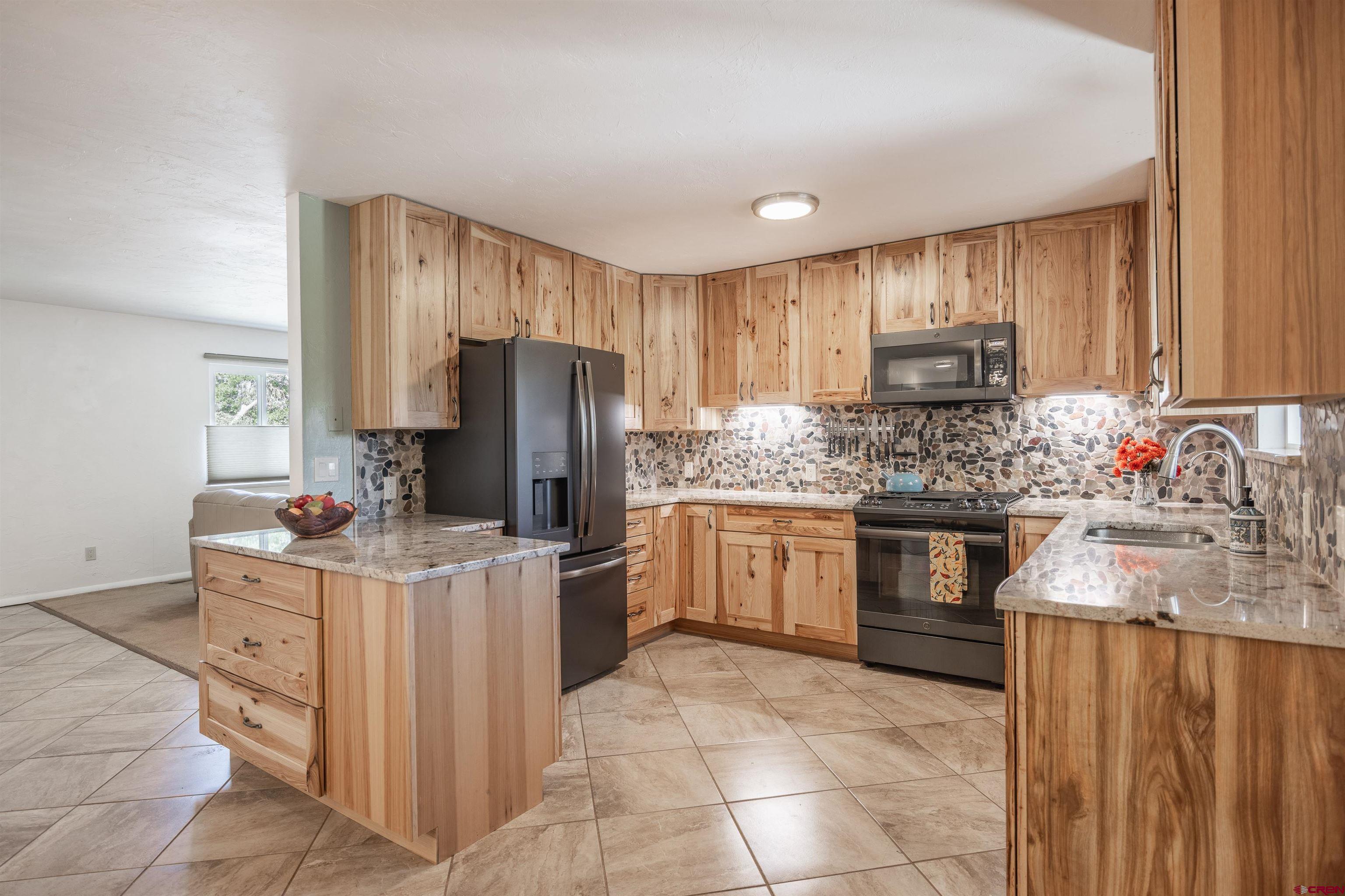 16574 6275th Road Montrose, CO 81403 - Photo 10 of 45 a kitchen with kitchen island cabinets a sink stove and refrigerator
