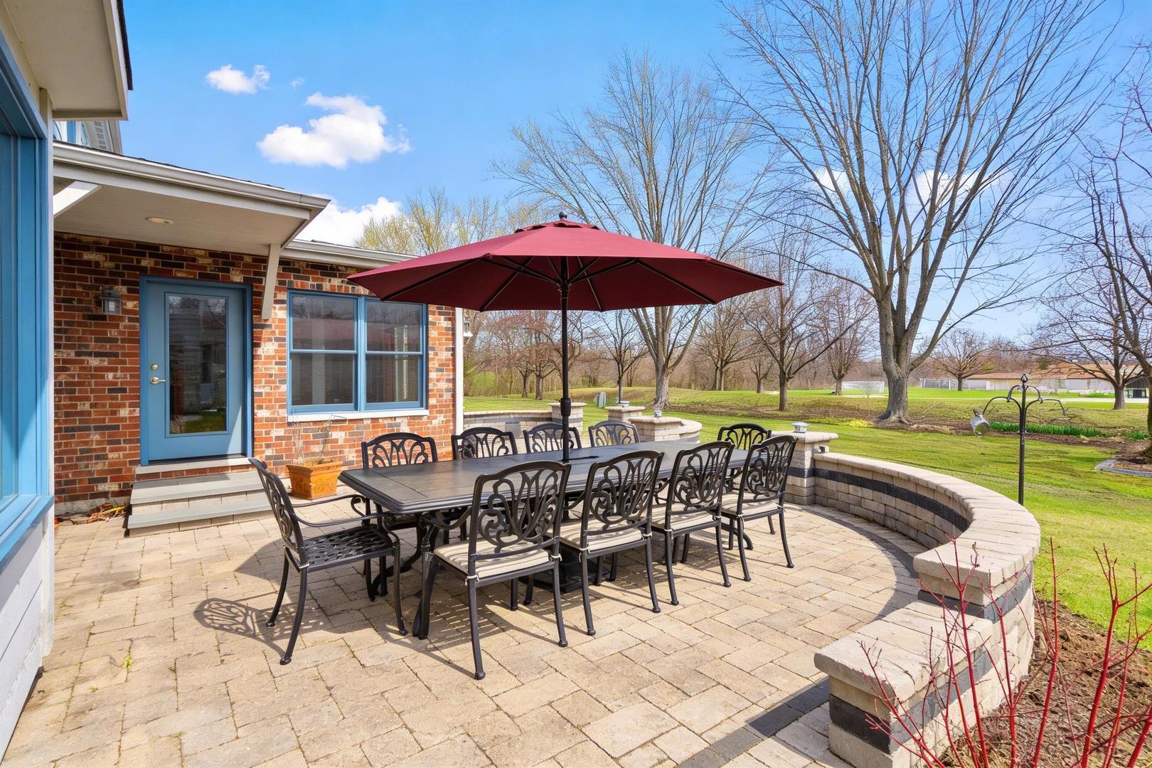 225 Fairway Drive Prospect Heights, IL 60070 - Photo 5 of 57 a view of a patio with a dining table and chairs under an umbrella with a barbeque grill and couches