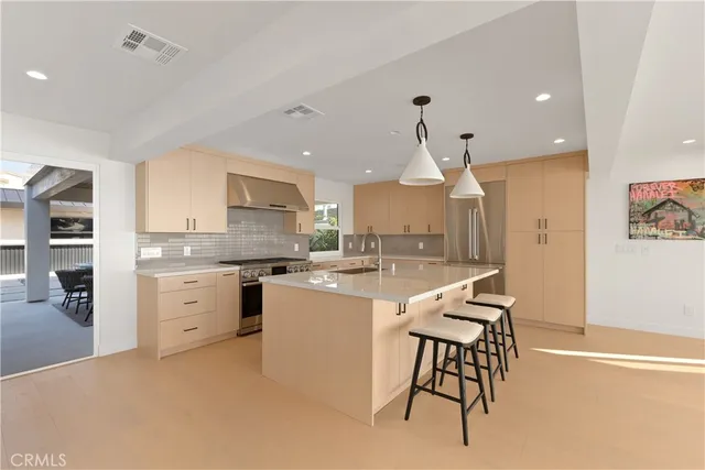 a kitchen that has a lot of cabinets in it and wooden floors