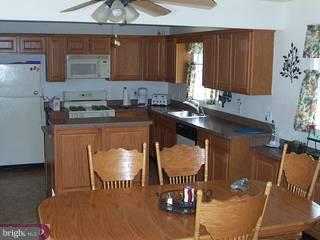 874 Pine Road Warminster, PA 18974 - Photo 3 of 6 a kitchen with a table chairs and a refrigerator