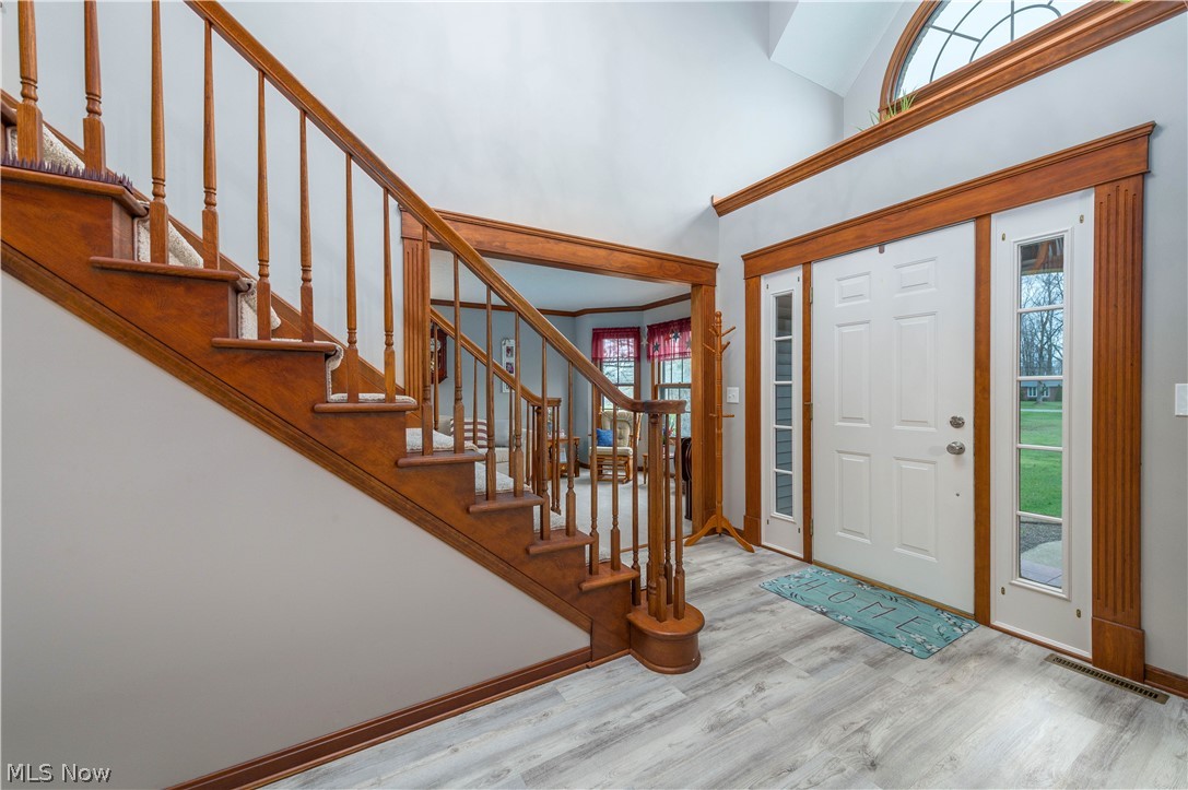 44565 Stang Road Elyria, OH 44035 - Photo 4 of 50 Entryway featuring plenty of natural light, red wood, waterproof vinyl plank flooring, and a high ceiling