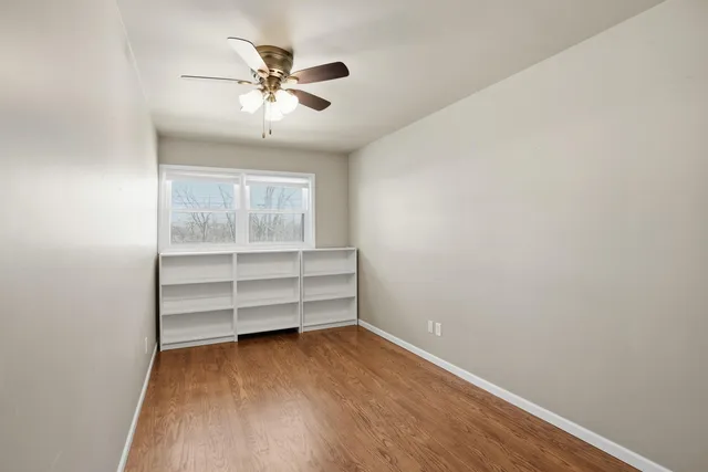 a view of room with a ceiling fan and wooden floor