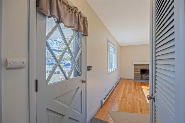a view of an empty room with a window and wooden floor