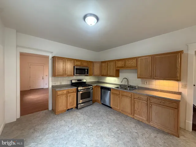 a kitchen with granite countertop a sink and stainless steel appliances
