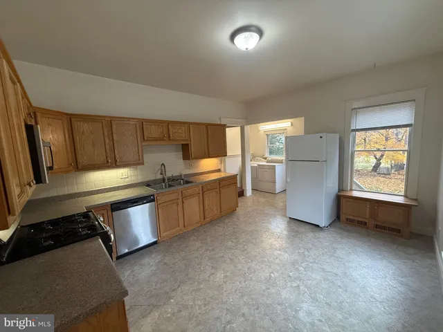 a kitchen with stainless steel appliances a refrigerator and wooden cabinets