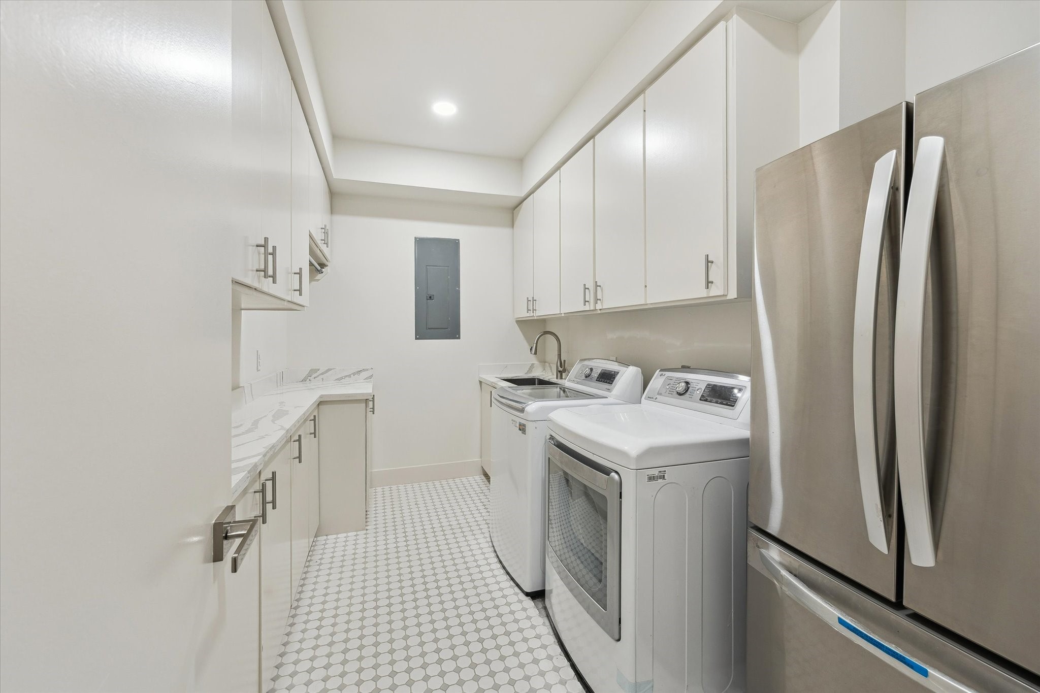 6348 Vanderbilt Street West University Place, TX 77005 - Photo 14 of 30 The laundry rom has generous cabinet storage, stone-look countertops, a utility sink, full-size washer and dryer, and a dedicated refrigerator space make this room as hardworking as it is well-designed.