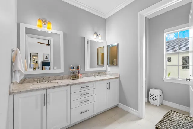 a bathroom with double vanity and a mirror