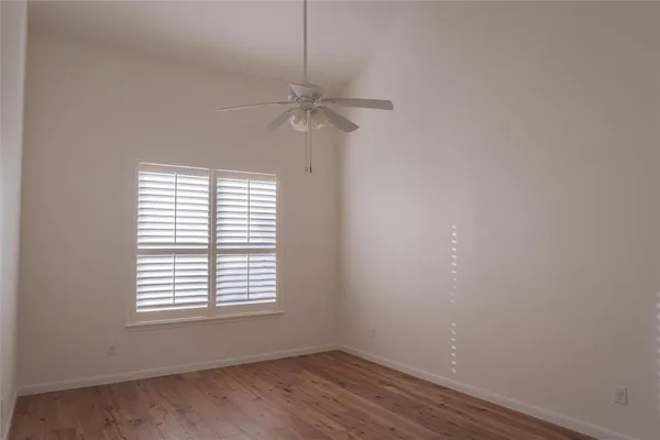 an empty room with a window and a fan