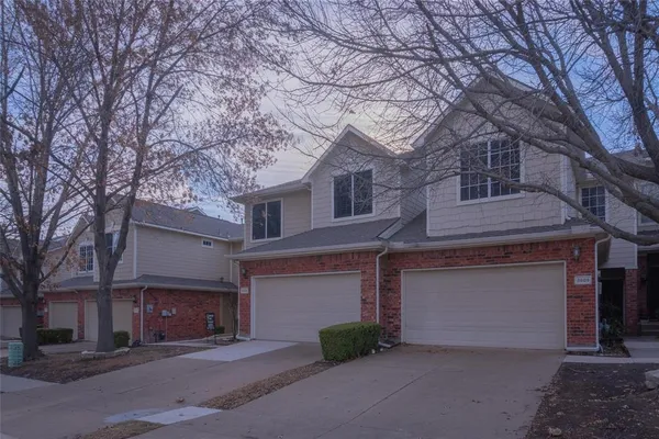 a front view of a house with yard and parking