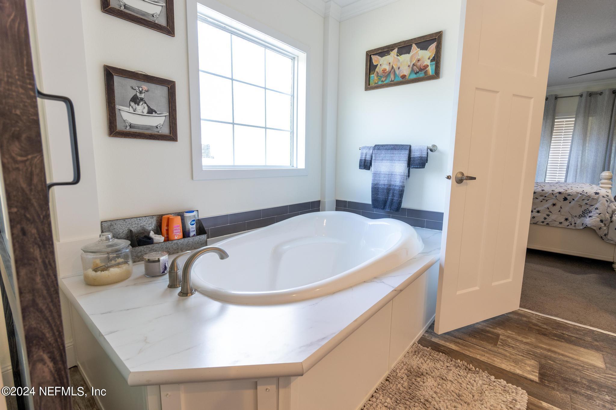 121 Honeysuckle Trail Hawthorne, FL 32640 - Photo 16 of 44 a bathroom with a tub sink and mirror