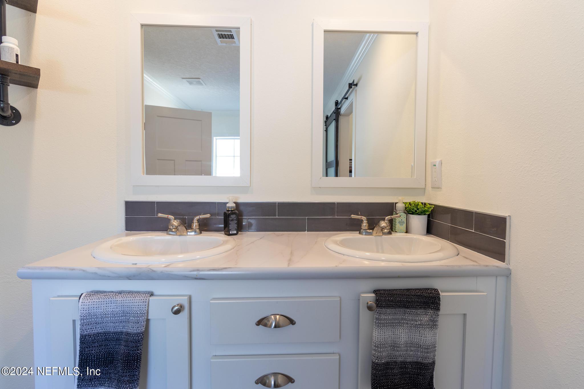 121 Honeysuckle Trail Hawthorne, FL 32640 - Photo 17 of 44 a bathroom with a sink and a mirror