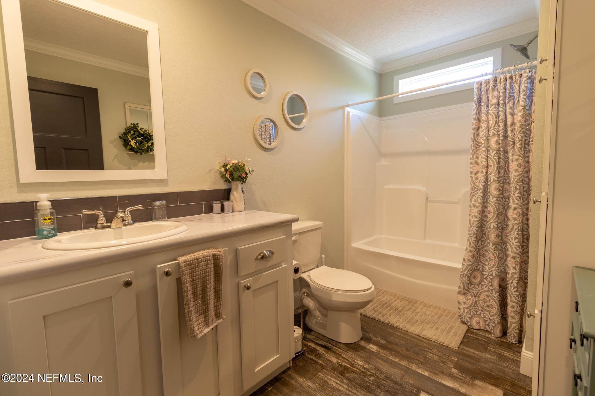 121 Honeysuckle Trail Hawthorne, FL 32640 - Photo 24 of 44 a bathroom with a sink toilet a mirror and shower