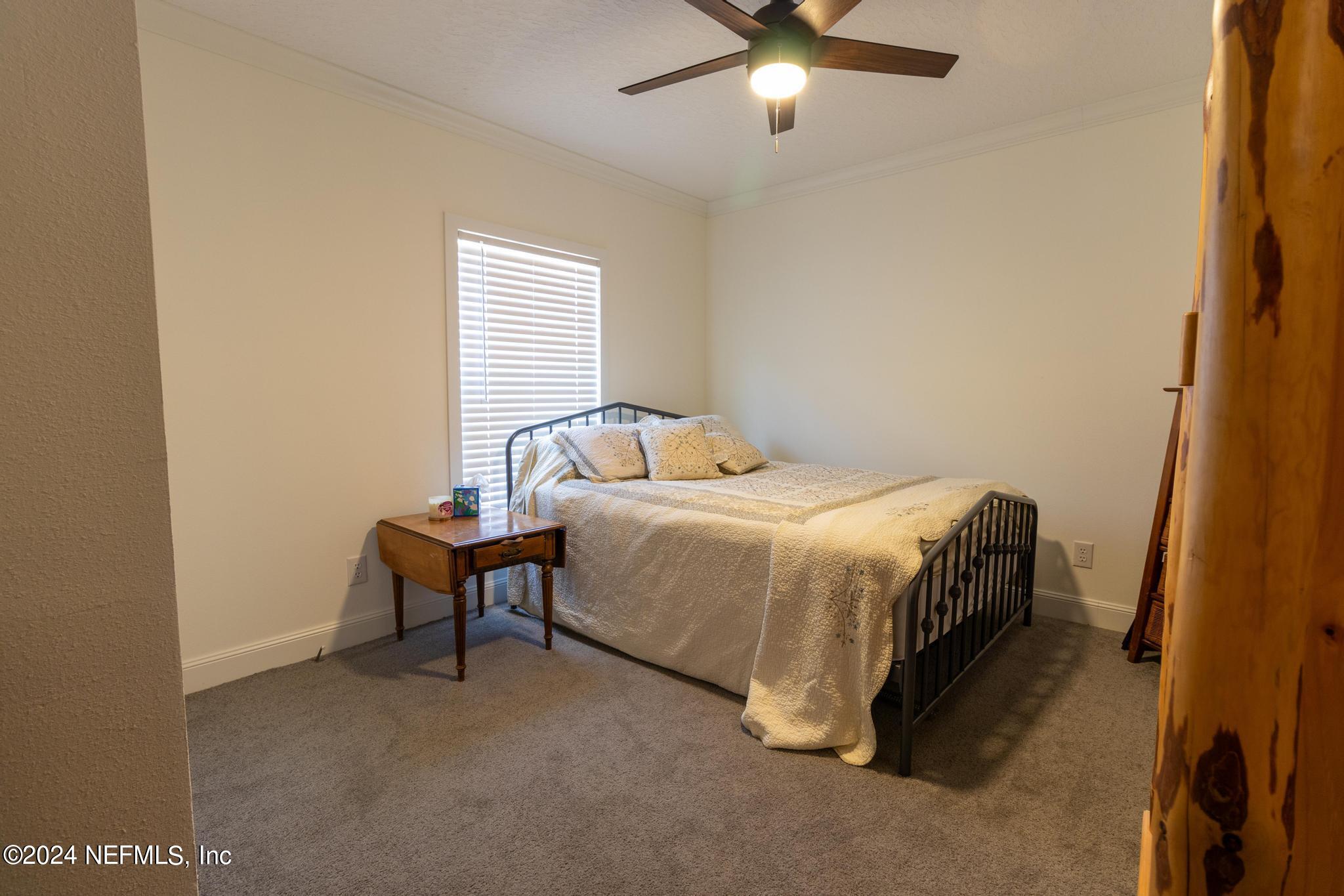 121 Honeysuckle Trail Hawthorne, FL 32640 - Photo 27 of 44 a bedroom with a bed and a chandelier