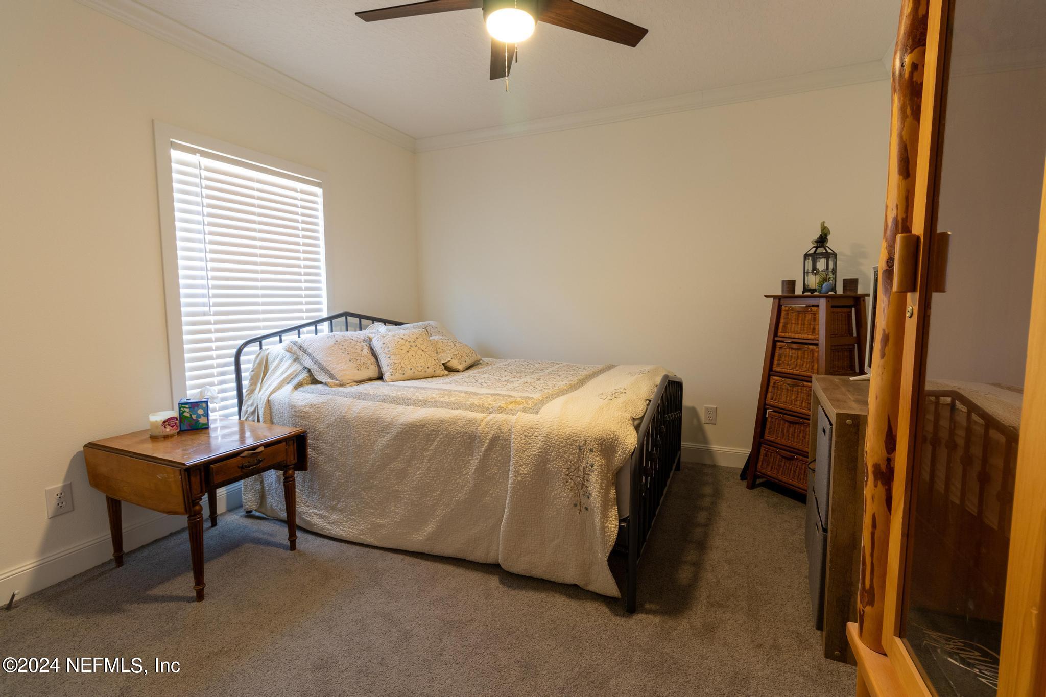 121 Honeysuckle Trail Hawthorne, FL 32640 - Photo 28 of 44 a bedroom with a bed and a chandelier