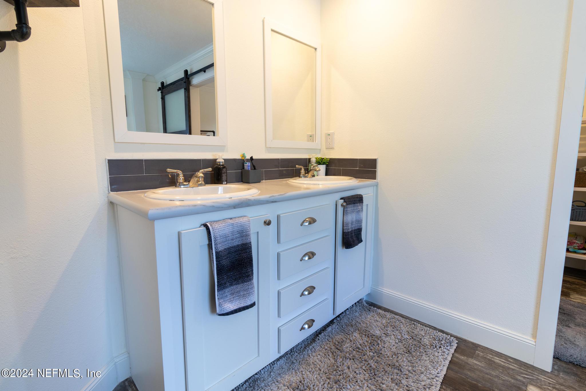 121 Honeysuckle Trail Hawthorne, FL 32640 - Photo 30 of 44 a spacious bathroom with a double vanity sink a mirror and