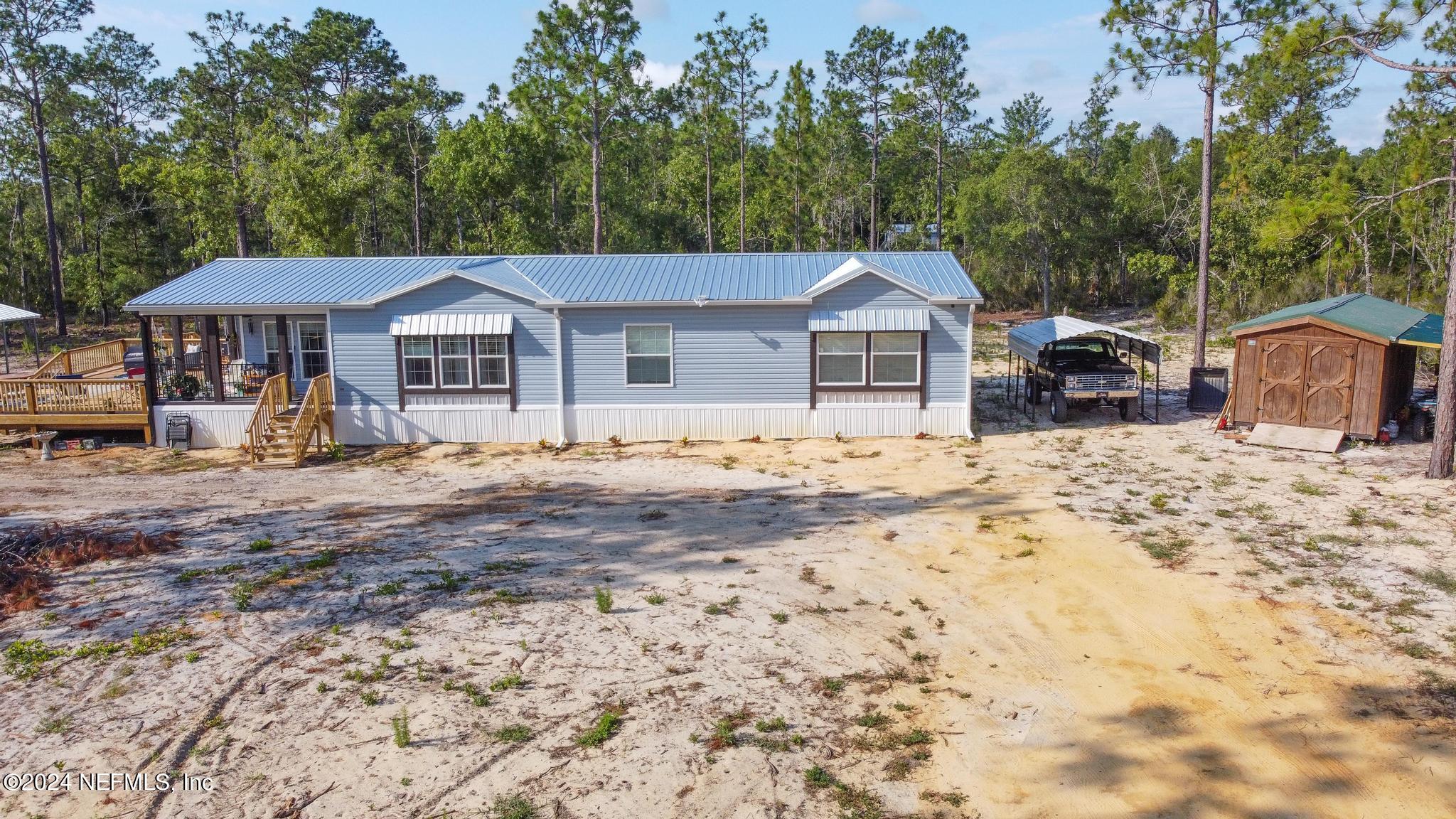 121 Honeysuckle Trail Hawthorne, FL 32640 - Photo 33 of 44 a view of a house with a yard covered in snow