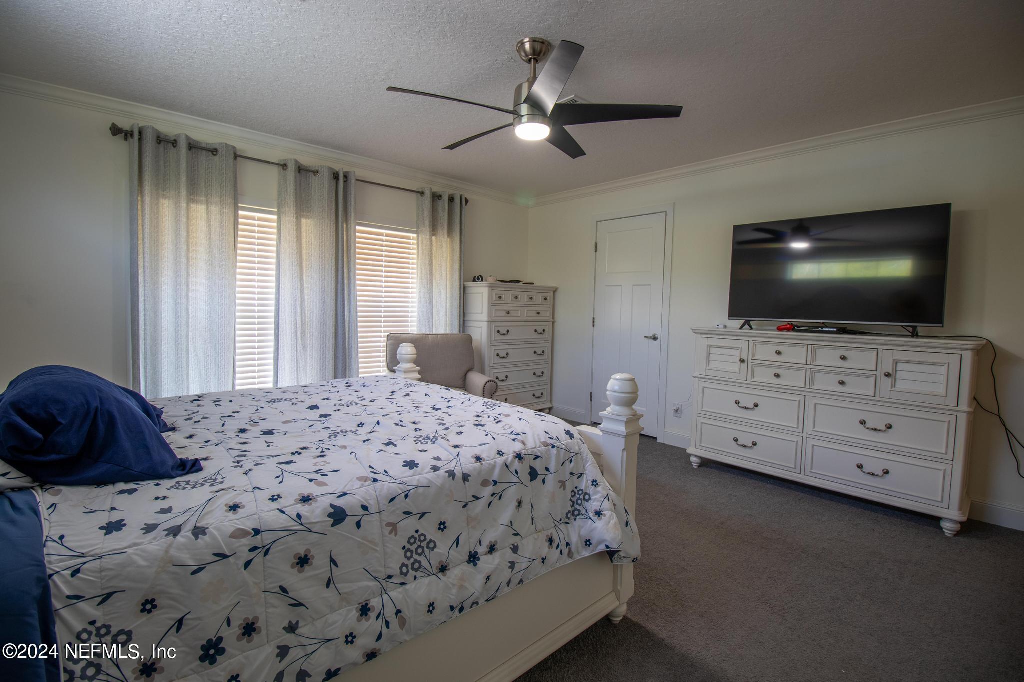 121 Honeysuckle Trail Hawthorne, FL 32640 - Photo 34 of 44 a bedroom with a bed and a flat screen tv