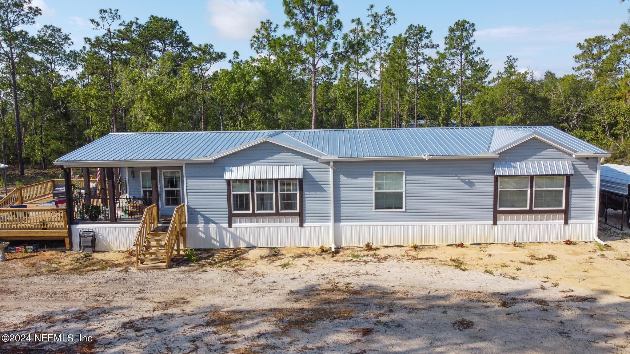 121 Honeysuckle Trail Hawthorne, FL 32640 - Photo 35 of 44 a front view of a house with a yard covered with snow in front of it