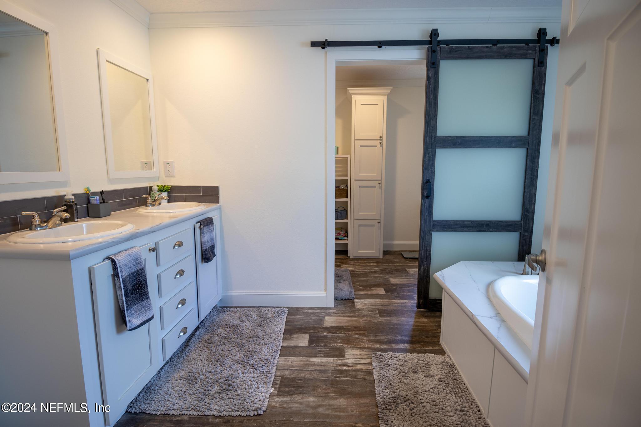 121 Honeysuckle Trail Hawthorne, FL 32640 - Photo 43 of 44 a bathroom with a sink a mirror and a bathtub