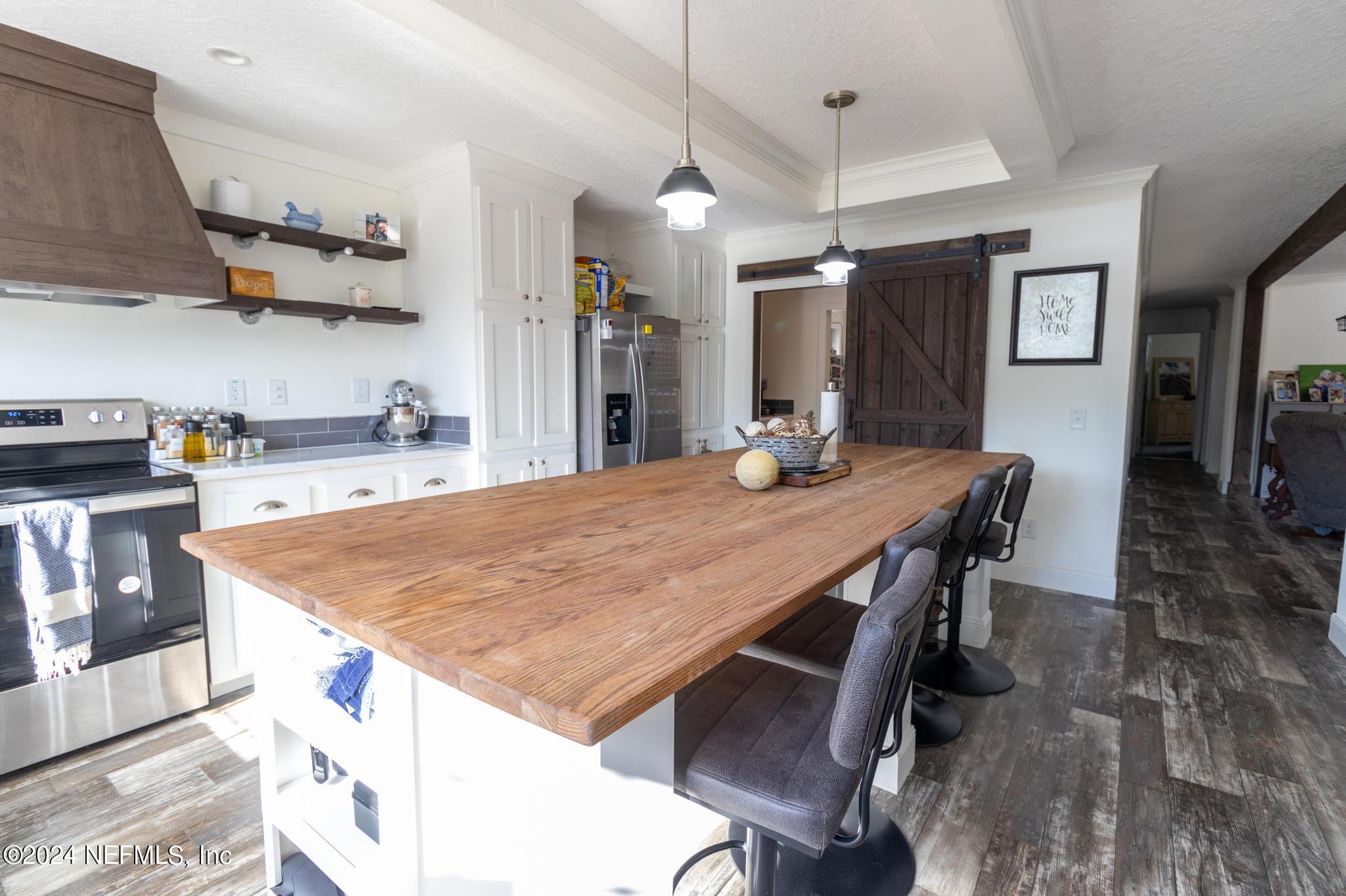 121 Honeysuckle Trail Hawthorne, FL 32640 - Photo 5 of 44 a kitchen with stainless steel appliances granite countertop a table chairs and a refrigerator