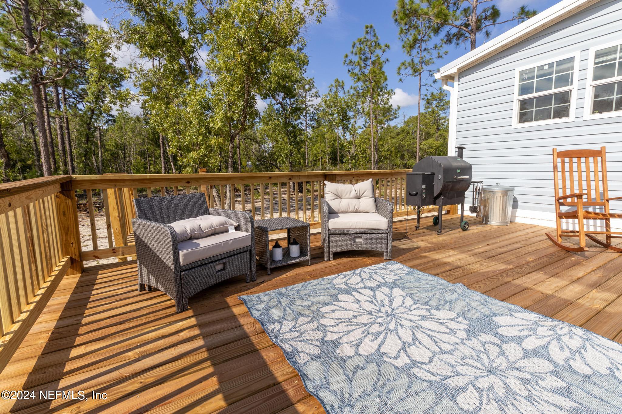 121 Honeysuckle Trail Hawthorne, FL 32640 - Photo 10 of 44 a balcony with couch and wooden floor