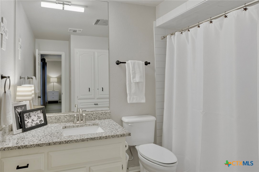 1710 Old Mill Road, Unit 12 Salado, TX 76571 - Photo 33 of 42 a bathroom with a granite countertop sink toilet and shower