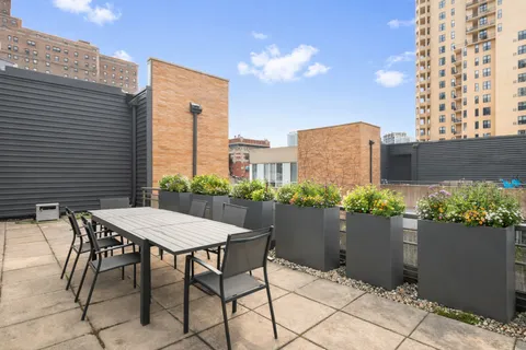 a view of a patio with plants and table and chairs