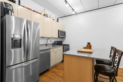 a kitchen with stainless steel appliances granite countertop a refrigerator and a stove top oven