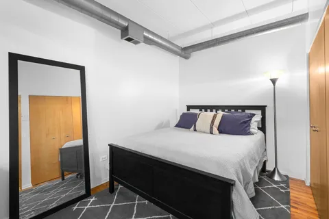 a bedroom with a bed and wooden floor